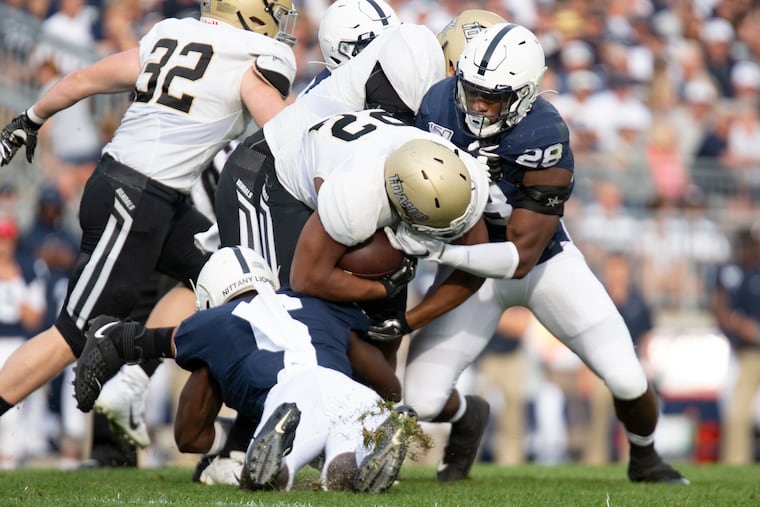 Penn State defenders Jayson Oweh (28) and Cam Brown (6) tackle Idaho running back Aundre Carter on Saturday.