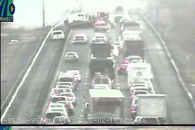 PennDOT traffic cameras capture the clearing of disabled vehicles from an accident jamming I-95 North. Top, a car is loaded onto a flatbed truck. Bottom, a van is backed onto another truck.