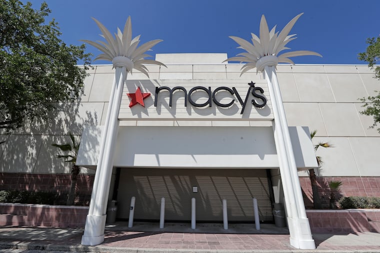 The entrance to a Macy's department store is closed behind barriers and storm shutters remains closed in Orlando, Fla. Macy’s said Thursday it’s laying off 3,900 corporate staffers, roughly 3% of its overall workforce, as the pandemic takes a financial toll on the retailer's business.