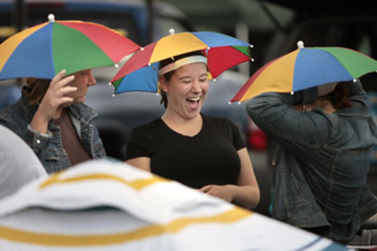 Joann Wentzell (left), Jeanne Staab and Christina Staab needed umbrella hats for protection from the elements prior to the Jimmy Buffet concert at the Tweeter Center tonight. (Elizabeth Robertson / Staff Photographer)