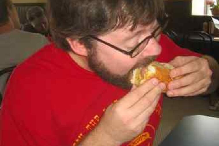 Hawk Krall tucks into a specialty of the house at Moe’s Hot Dog House, 26th and Washington.