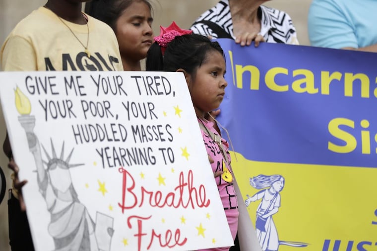 Young girls take part in a vigil at San Fernando Cathedral in San Antonio for victims who died as a result of being transported in a tractor-trailer.