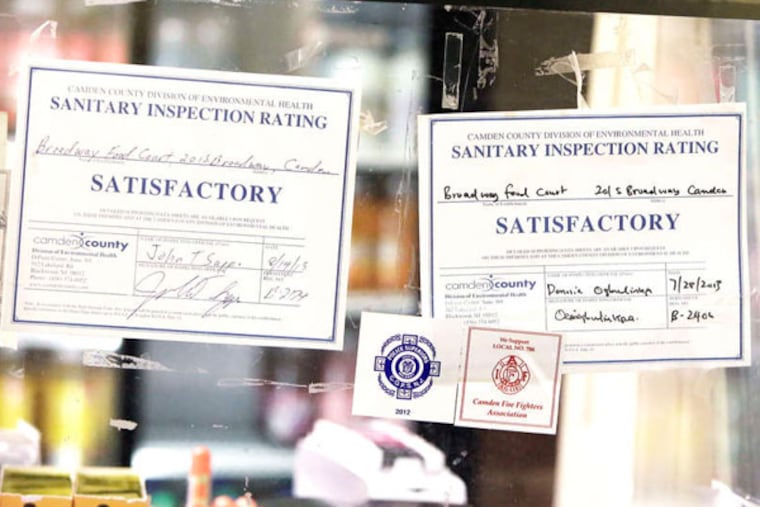 Restaurant inspection findings are summarized in plain view at the counter of the Broadway Food Court and Aziz Corner Marketplace in Camden. ELIZABETH ROBERTSON / Staff Photographer