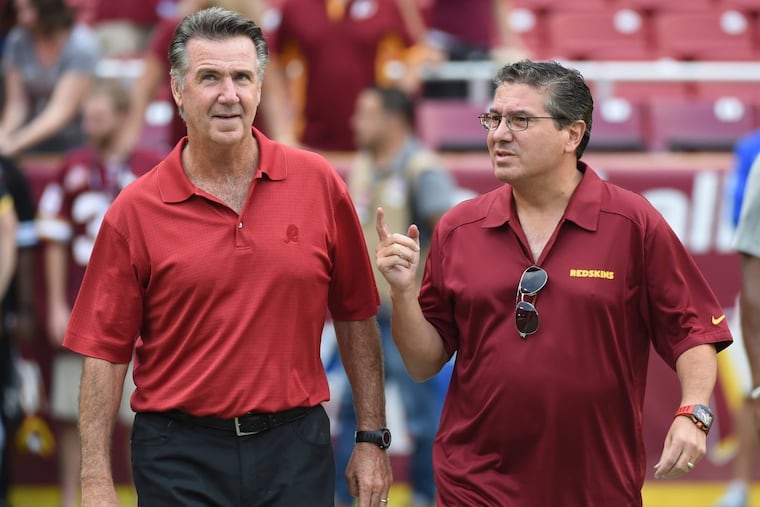 Washington Redskins owner Dan Snyder (right) and team president Bruce Allen walk onto the field prior to a 2015 game against the Detroit Lions.