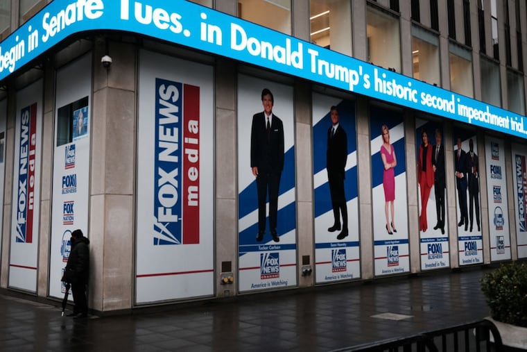 News headlines on the impeachment trial of Donald Trump are displayed outside the Fox headquarters in February 2021.
