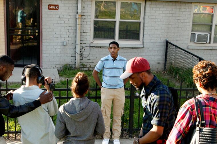 Nasir Smith, center, being filmed by Darren Wyes-Nunez while Terence Lewis, on the left checks things out. Nasir didn't hesitate when asked to describe his neighborhood: "Hell. It's Hell." (RON CORTES/Staff Photographer)