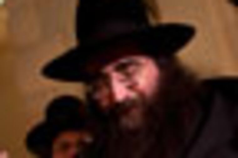 FILE - In this July 11, 2011 file photo, a man kisses the hand of Rabbi Yoshiyahu Pinto at a wedding in Lod, central Israel. Rabbi Pinto has been placed under house arrest and banned from traveling abroad, as police investigate suspicions that he bribed a high-ranking officer for access to his police file. (AP Photo/Oded Balilty, File)