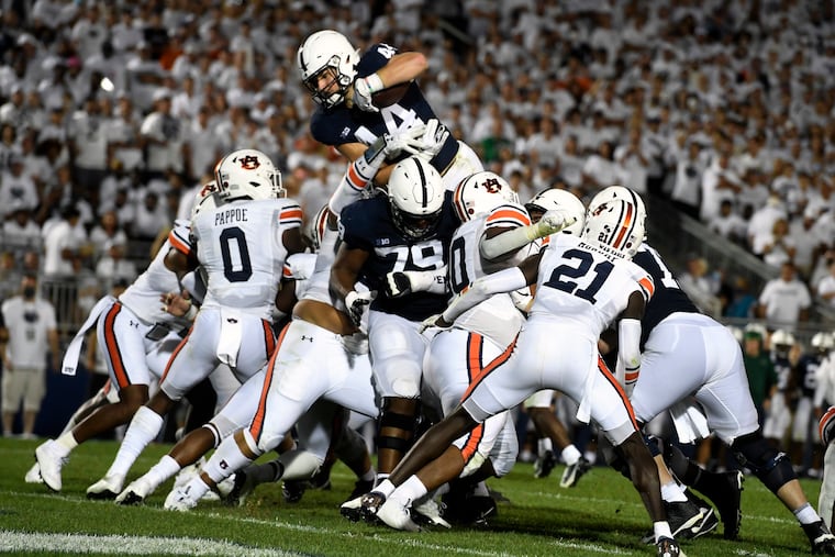Penn State's Tyler Warren dives over Auburn linebacker Owen Pappoe to score a third-quarter touchdown on Saturday.