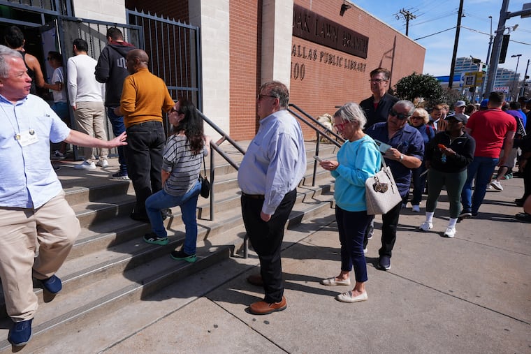 Voters stand in line to vote early for the primary election, in Dallas, Tuesday.