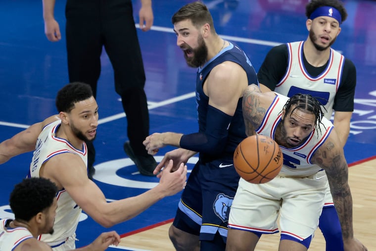 The Sixers' Tobias Harris (lower left), Ben Simmons and Mike Scott (lower right) chasing a rebound in the second quarter of Sunday's loss.