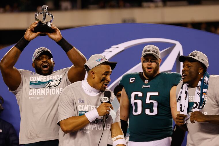 Eagles quarterback Jalen Hurts sings the Eagles Fight Song with teammates offensive tackle Lane Johnson and wide receiver A.J. Brown as defensive tackle Fletcher Cox, holds the NFC Championship trophy after they beat the San Francisco 49ers on Sunday, January 29, 2023 in Philadelphia.