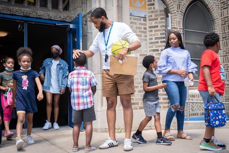 Trent Petty, site leader at a Philadelphia Freedom School at Mastery Charter Prep Elementary, comforts a student as children leave the building to go to recess.