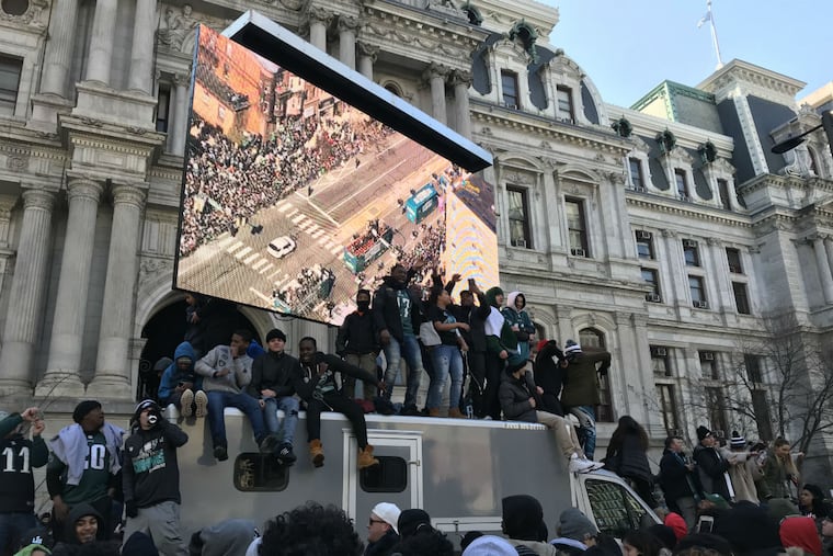 Eagles fans climbed the Jumbotron TV at City Hall to get a better vantage point on the team's Super Bowl victory parade.