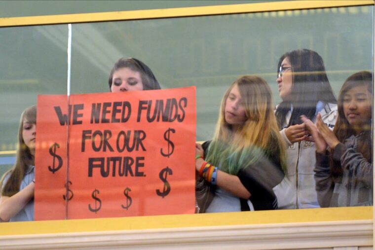 Students (no ids) in the balcony hold signs during Philadelphia school district budget hearings before City Council May 7, 2014. ( TOM GRALISH / Staff Photographer