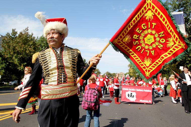 Joseph Janik of the Polish National Alliance Council 171 of the Lehigh Valley stands with a replica of the banner carried by Gen. Casimir Pulaski during the Revolutionary War. Janik was marching in the 2012 Pulaski Day Parade. ( Charles Fox / Staff Photographer )