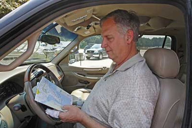 Steve Guy of Harrisburg checks his map before leaving the Pennsylvania Turnpike Valley Forge Plaza. Highway traffic has dropped, but cops are writing as many tickets as ever and traffic jams persist. (Michael S. Wirtz / Inquirer).