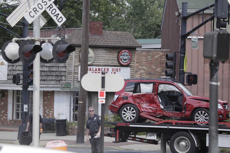 Police and emergency personnel prepare to remove a vehicle that was struck by a train at Clements Bridge Road and East Atlantic Avenue in Barrington, N.J., on Aug.18, 2016.