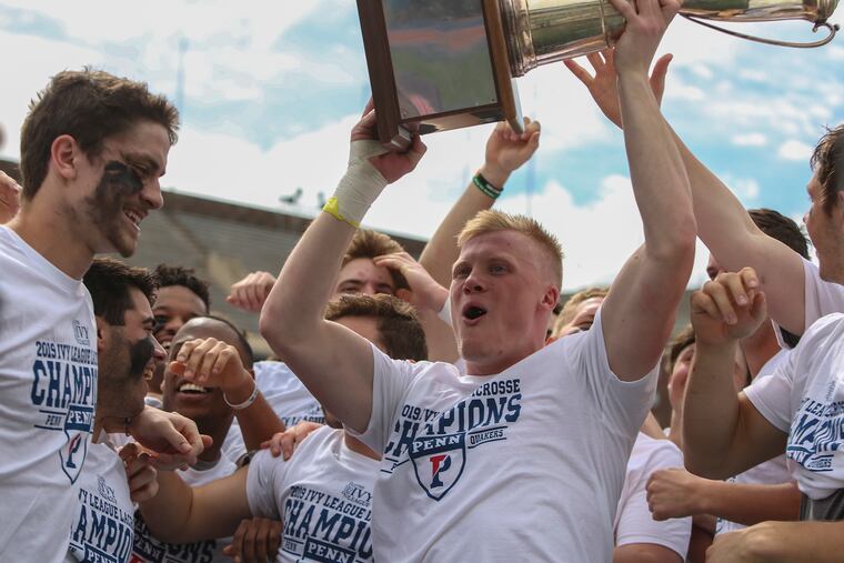 Penn senior Tyler Dunn hoists the Ivy League trophy after the Quakers defeated Yale to complete a 6-0 league season.