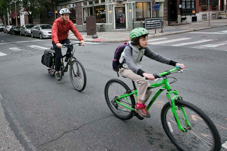 Bicyclists make their way north along the 13th Street bike lane at Pine in Center City.