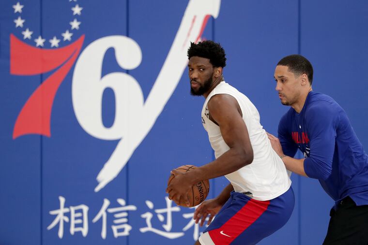 Sixers center Joel Embiid (left) working with Dwayne Jones in April 2019.
