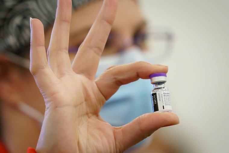 A pharmacist holds a vial of the COVID-19 vaccine at Cooper University Health Care in Camden, Tuesday, Dec. 15, 2020. Cooper University Health Care is among the first group of hospitals in New Jersey to receive the new COVID-19 vaccine.