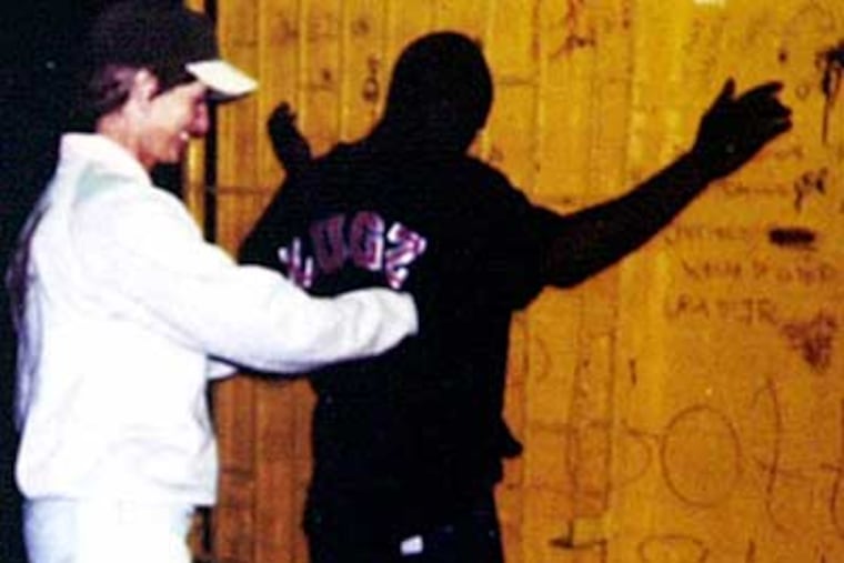 In this 1996 photograph, New Jersey Gov. Christie Todd Whitman goes through the motions of searching Rolax while accompanying Camden police officers on patrol.