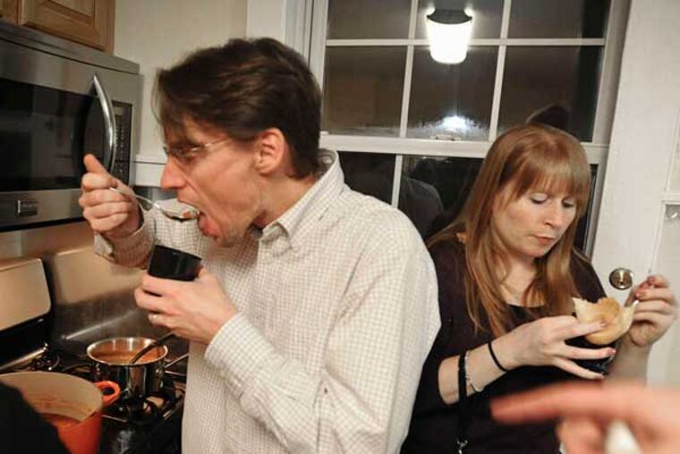 Chris Roselle, Pam Daly sample soup at the "What a Crock" 10th-anniversary party at the home of Sara Goddard and Joe Daly. Goddard created a "best soup name" category, encouraging participants to get creative. RON TARVER / Staff Photographer