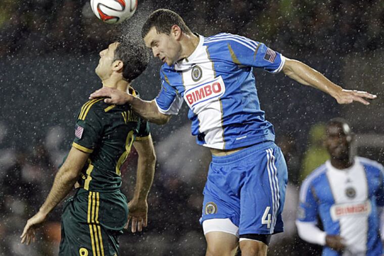 Union defender Austin Berry, right, heads the ball away from Portland Timbers midfielder Diego Valeri during the second half of an MLS soccer game in Portland, Ore., Saturday, March 8, 2014. The teams tied 1-1. (Don Ryan/AP)