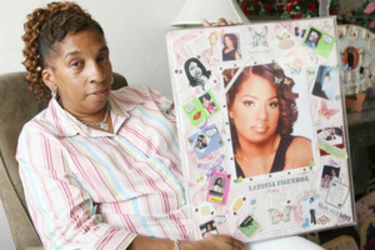 Emergency-room clerk Lizz Brown, who has created personalized memorial plaques for hundreds of the city's murder victims, holds one she made for the family of LaToyia Figueroa.