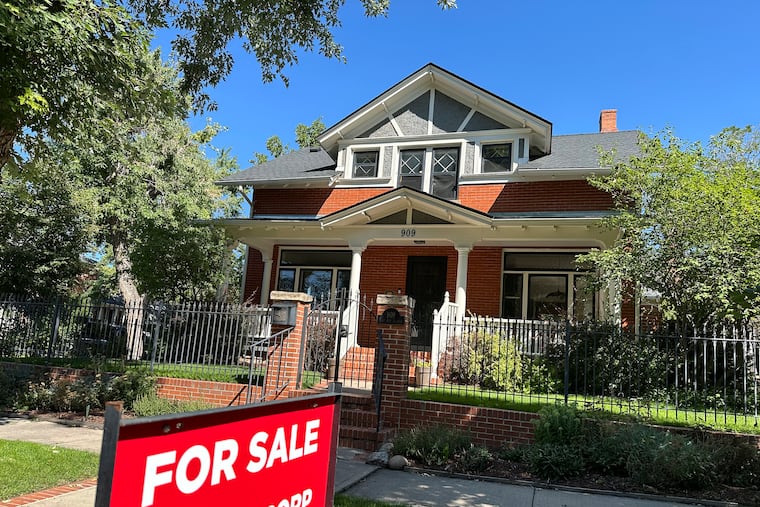 A for sale sign stands outside a home on the market in central Denver in August 2024.