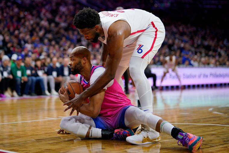 Joel Embiid tries to pry the ball away from the Wizards' Taj Gibson in the first half. Embiid finished with a game-high 34 points.