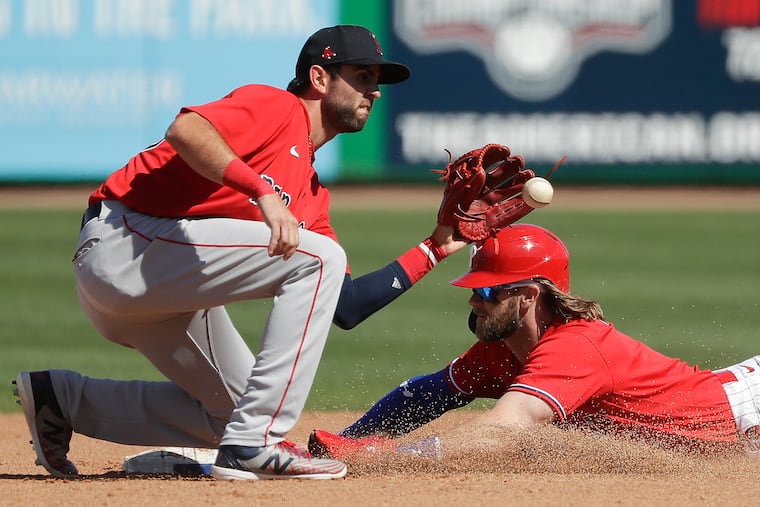 C.J. Chatham, acquired Monday by the Phillies from the Boston Red Sox, attempts to apply a tag to Bryce Harper during a spring training game last year.