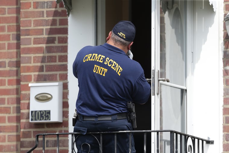 A crime scene investigator photographs at the scene of an apparent murder suicide at 4035 Meridian Street in Philadelphia, PA on August 17, 2018. DAVID MAIALETTI / Staff Photographer
