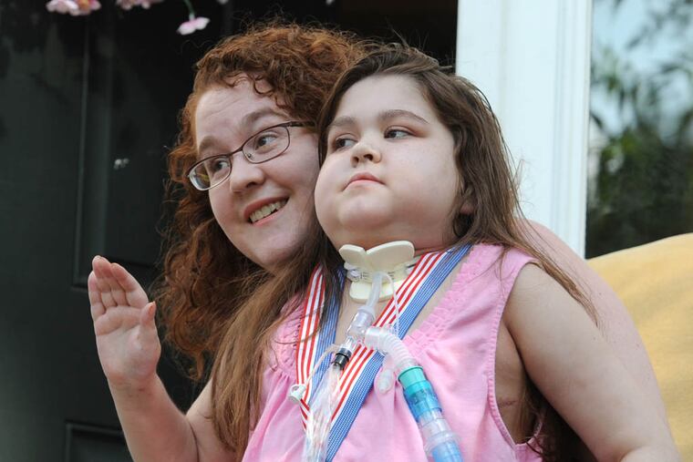 Sarah Murnaghan, the 11-year-old double-lung transplant recipient, sits in her mother Janet's lap and waves goodbye after meeting the media from the front stoop of the family home in Newtown Square Aug. 27, 2013. ( CLEM MURRAY / Staff Photographer )
