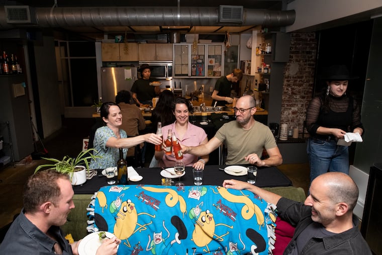 Dylan Jackson (from left), Rebecca Crosby, Gayle Burstein, Jordan Teitelbaum, and Sharone Bilenkin toast during Spaghetti Western night at Couch Cafe, a supper club at Liz Grothe’s apartment in Northern Liberties.