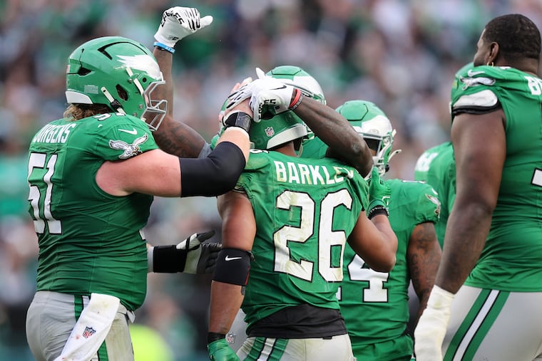 Eagles running back Saquon Barkley is congratulated by teammates before he left the game in the fourth quarter on Sunday.