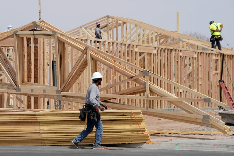 Construction workers install a lumber roof at a new home build Tuesday, April 1, 2025, in Laveen, Ariz.