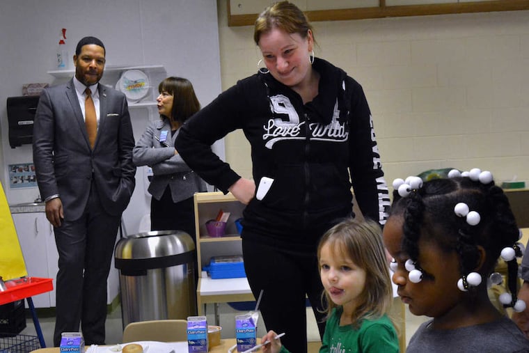 On the first day of pre-K at at SPIN Parkwood (from left) Chief Education Officer of Philadelphia Otis Hackney and SPIN President CEO Kathy Kathy Brown-McHale talk as parent Desiree Tritz watches her daughter Madison Hoffman Green,4, and fellow students Makayla Grant,4 , eat breakfast.