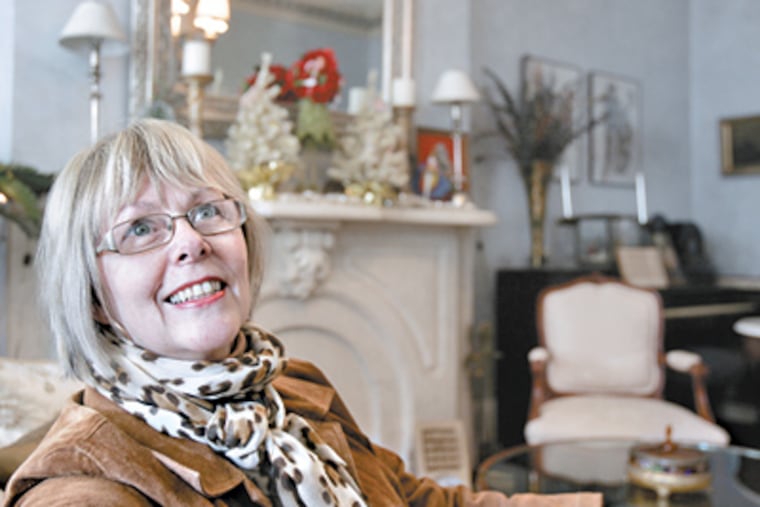 Betty Gainsborough sits in the living area of her Fishtown home, which features cherry-stained pine flooring, chandeliers, a marble fireplace, and intricately crafted ornamental plaster skirting the ceiling. (Bonnie Weller / Staff Photographer)
