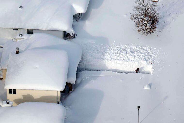 A man attempts to dig out his driveway in Depew, N.Y. More snow was on the way late Thursday.