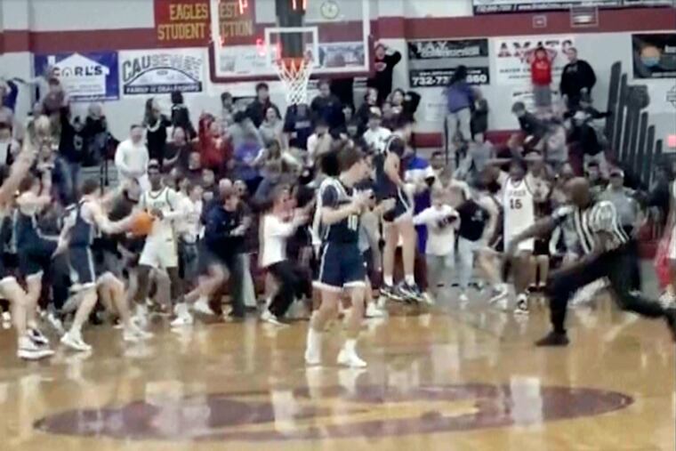 In this image taken from video provided by Joshua Clyburn, a game official, right, signals good basket as Manasquan players celebrate after Griffin Linstra made a basket in the closing second against Camden in the NJSIAA state tournament.