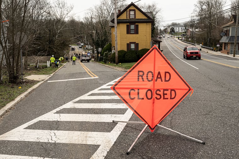 Officials investigate the collapse of a road in Mullica Hill, Gloucester County, Friday.