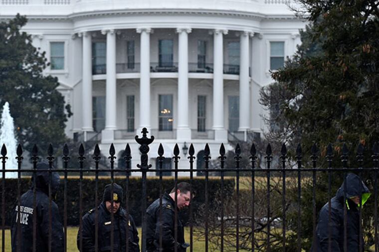 Secret Service officers search the south grounds of the White House on Monday. SUSAN WALSH / Associated Press
