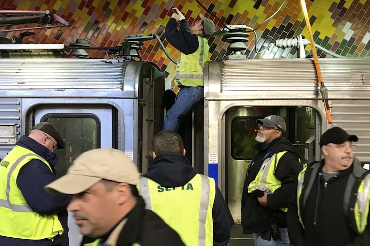 SEPTA officials at Jefferson Station in Center City Philadelphia investigate a Regional Rail train on Friday morning. The body of a burned male was found on the roof of the railcar.