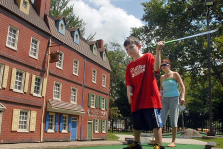 Finnigan Nemo, 7, and a friend's mother, Kati Malloy, of the Northeast, play miniature golf in the square, which reopened three years ago today. Renovations have created a popular spot for locals and tourists alike.