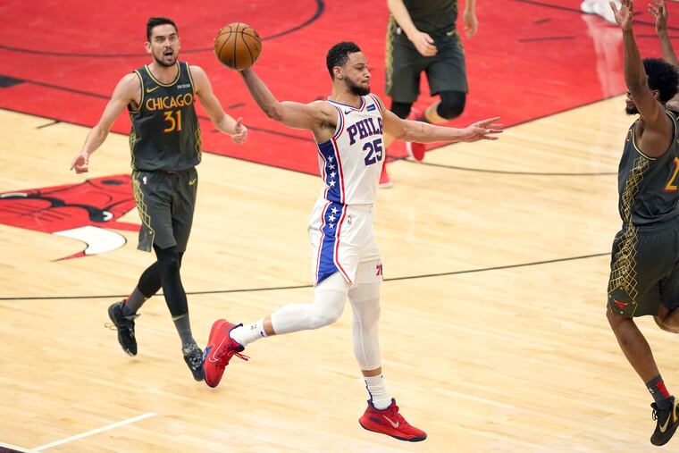 Ben Simmons saves the ball from going out of bounds as the Bulls' Tomas Satoransky (31) and Thaddeus Young watch on Monday night.