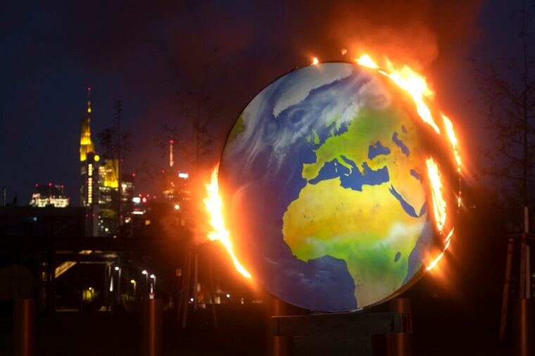 A makeshift globe burns in front of the European Central Bank in Frankfurt, Germany, Wednesday, Oct. 21, 2020. Activists of the so-called "KoalaKollektiv", an organization asking for climate justice, protested with the burning of the globe against the ECB's climate policy.
