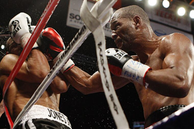 Bernard Hopkins, right, punches Roy Jones Jr. during their light heavyweight boxing match on Saturday. (AP Photo/Isaac Brekken)