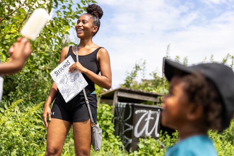 Labriana Mitchell, 20, of West Kensington, Philadelphia, is out with her son enjoying a day out and had came across a workshop with the neighborhood residents about the effects of heat, urban heat islands and climate change based on a coloring book created for the Heat Response PHL project on Saturday, Aug., 14, 2021.