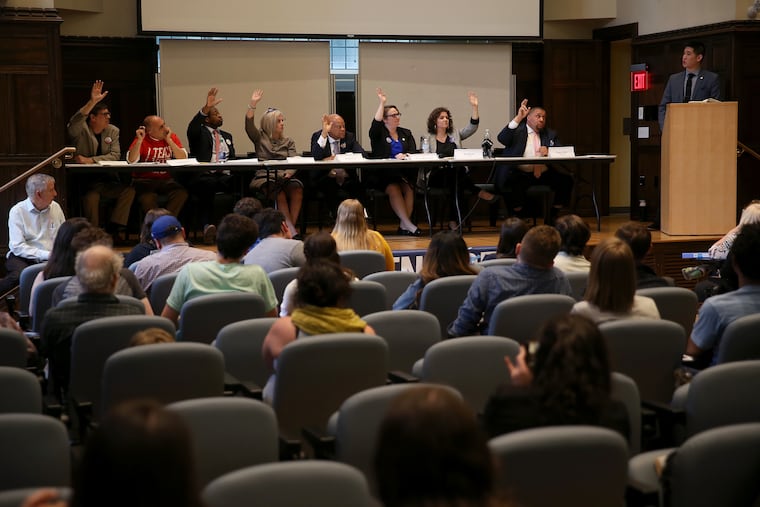 Candidates raise their hands in response to questions during a forum for Democratic city commissioner candidates on the University of Pennsylvania campus on Tuesday, April 23, 2019. Eight candidates participated in the debate, which was hosted by Penn Democrats, Committee of Seventy, and the League of Women Voters of Philadelphia. From left: Marwan Kreidie, Luigi Borda, Kahlil Williams, Lisa Deeley, Dennis Lee, Moira Bohannon, Jen Devor, and Omar Sabir.